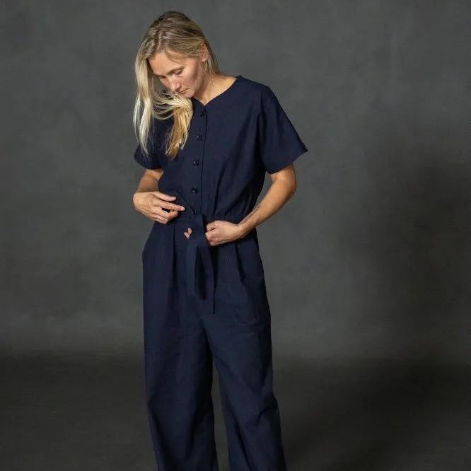 Person wearing Merchant & Mills' Cassidy jumpsuit in navy blue against a dark gray background