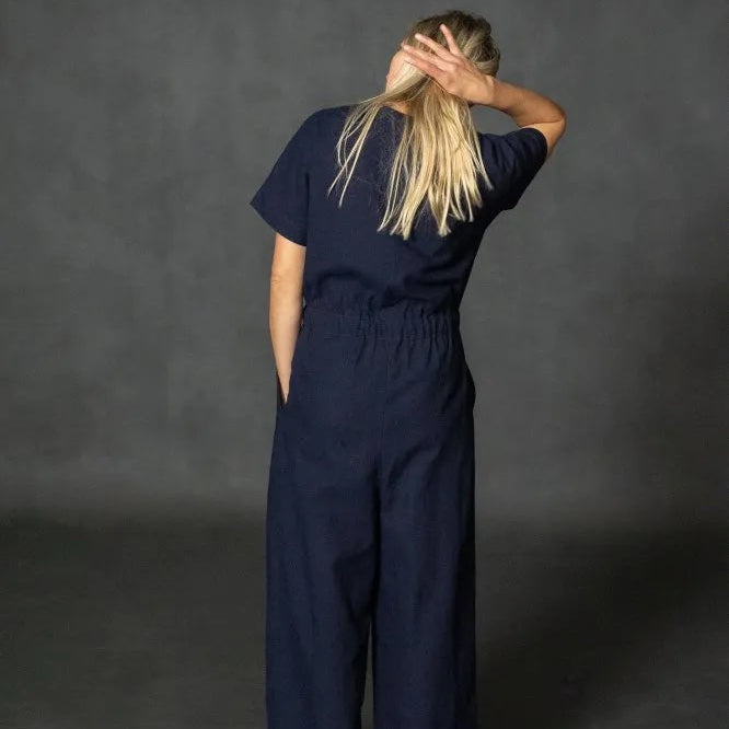 Person wearing Merchant & Mills' Cassidy jumpsuit in navy blue against a dark gray background