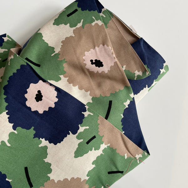 Camouflage-patterned fabric with green, brown, and blue colors on a white background